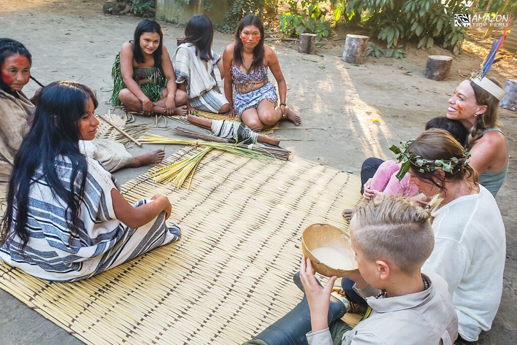 Travelers sharing a traditional drink with women of a native community