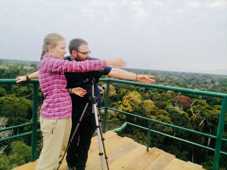 Travelers with a spotting scope on top of the canopy tower, above the Tambopata rainforest